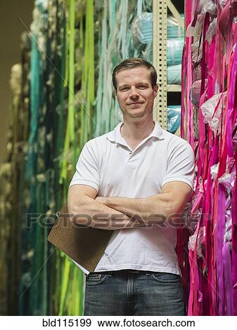 Caucasian worker smiling in textile factory View Large Photo Image Stock Photo - Caucasian worker smiling in textile factory. Fotosearch