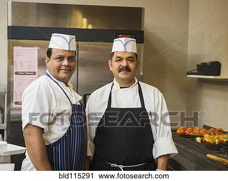 Stock Image - Chefs smiling in kitchen. Fotosearch