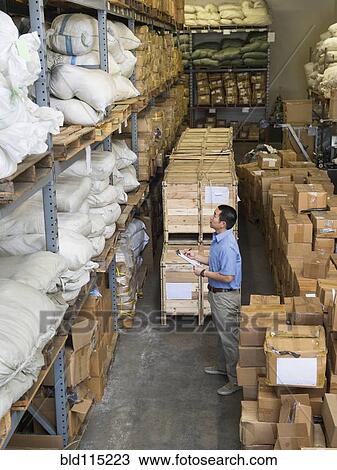 Stock Image - Chinese worker using clipboard in textile factory. Fotosearch
