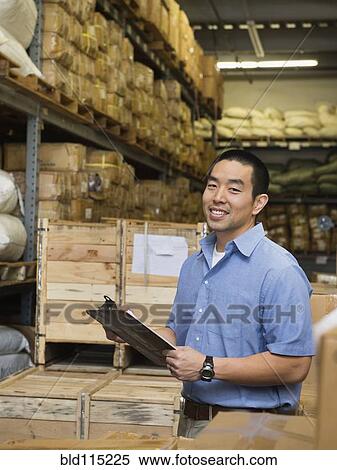Stock Photography - Chinese worker using clipboard in textile factory. Fotosearch
