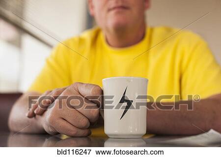 Stock Photo - Close up of Caucasian man having cup of coffee. Fotosearch