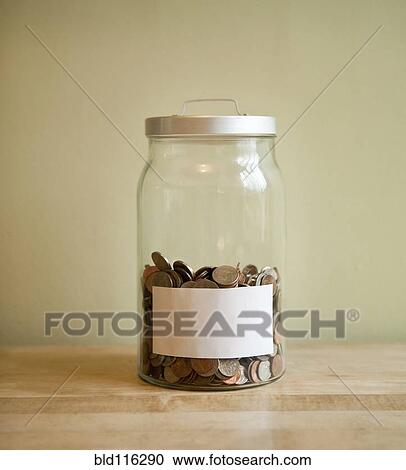 Stock Image - Coins in blank labeled jar. Fotosearch
