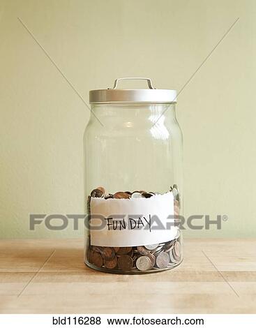 Stock Photo - Coins in 'fun day' jar. Fotosearch