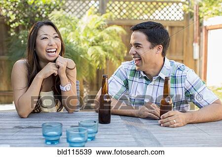 Stock Photo - Couple having beers in backyard. Fotosearch