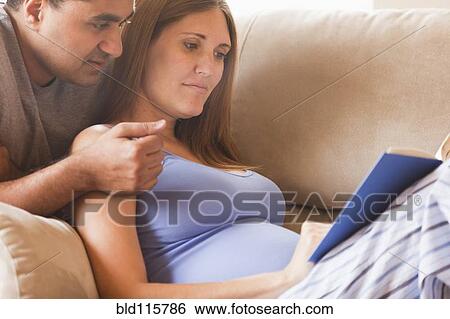 Stock Photograph - Couple reading together on sofa. Fotosearch