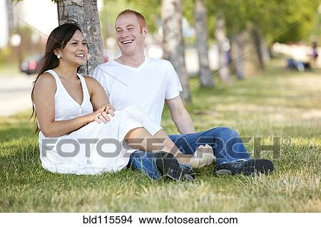 Couple relaxing in park View Large Photo Image Picture - Couple relaxing in park. Fotosearch