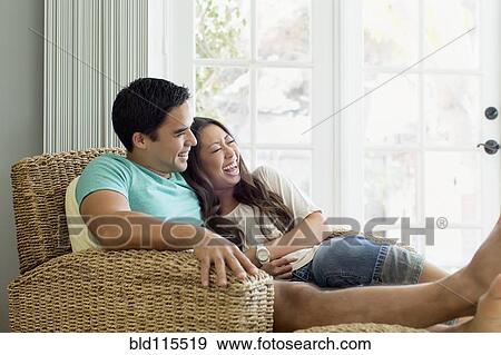 Couple relaxing together in armchair View Large Photo Image Stock Photo - Couple relaxing together in armchair. Fotosearch