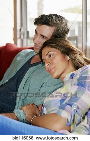 Stock Photograph - Couple relaxing together on sofa. Fotosearch