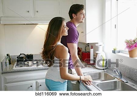 Stock Photo - Couple standing together in kitchen. Fotosearch