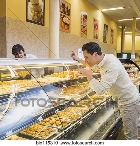 Stock Image - Customer ordering at restaurant counter. Fotosearch