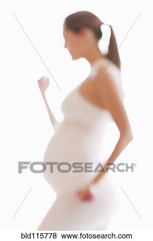 Stock Photo - Defocused view of pregnant woman lifting weights. Fotosearch