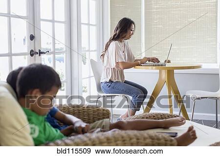 Stock Photo - Family relaxing in living room. Fotosearch