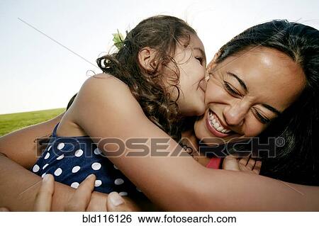 Stock Photograph - Girl kissing mother on cheek. Fotosearch