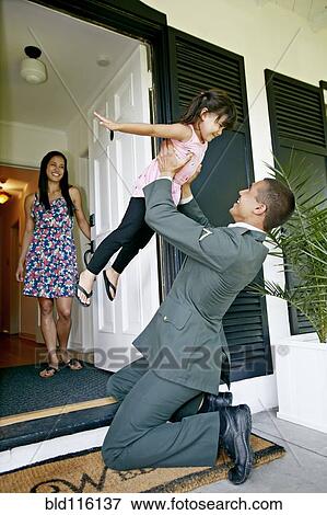 Stock Photo - Girl playing with soldier father at door. Fotosearch