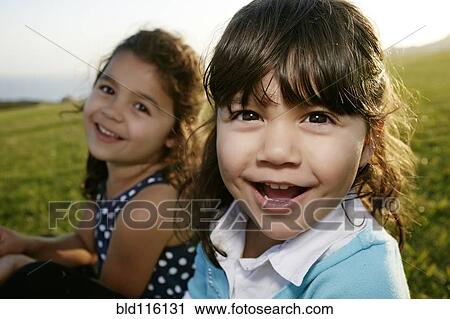 Stock Image - Girls playing in field. Fotosearch