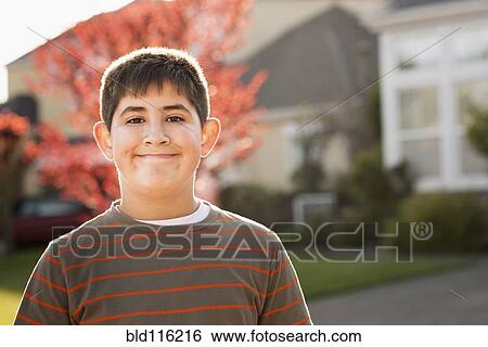 Stock Photograph - Hispanic boy smiling outdoors. Fotosearch