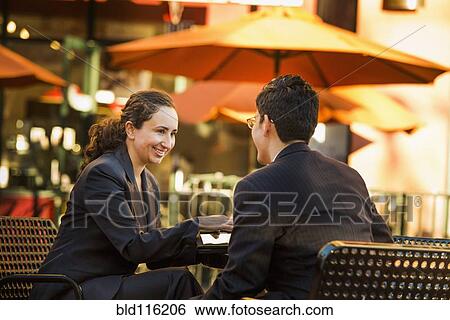 Stock Photograph - Hispanic business people working at cafe. Fotosearch