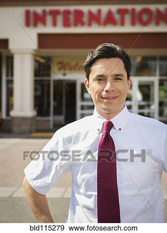 Hispanic businessman standing outside grocery store View Large Photo Image Stock Photo - Hispanic businessman standing outside grocery store. Fotosearch