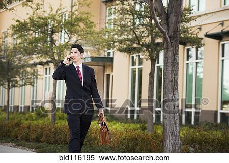 Stock Photography - Hispanic businessman talking on cell phone. Fotosearch