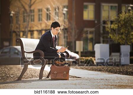 Stock Photo - Hispanic businessman using cell phone. Fotosearch
