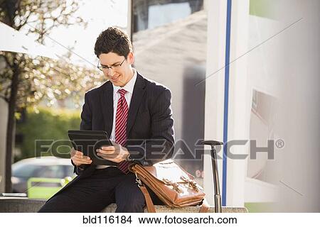 Picture - Hispanic businessman using tablet computer. Fotosearch