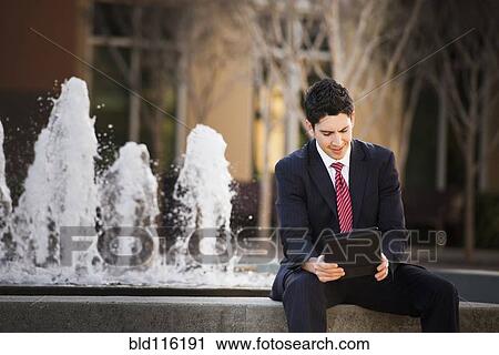 Stock Image - Hispanic businessman using tablet computer. Fotosearch