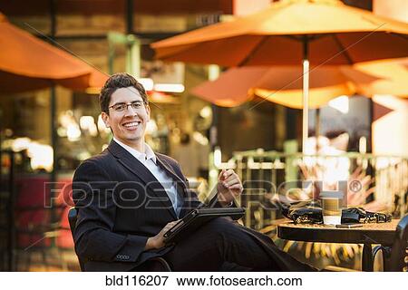 Stock Photo - Hispanic businessman working at cafe. Fotosearch