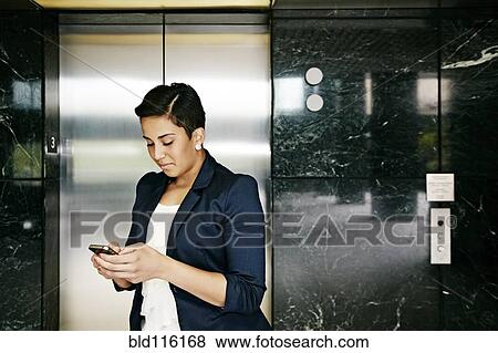 Stock Photo - Hispanic businesswoman using cell phone. Fotosearch