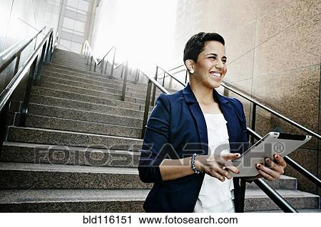 Stock Image - Hispanic businesswoman using tablet computer. Fotosearch