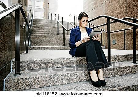 Stock Image - Hispanic businesswoman using tablet computer. Fotosearch