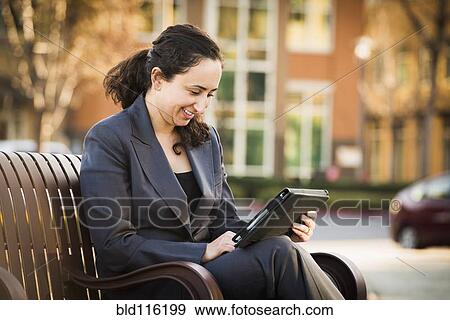Stock Photo - Hispanic businesswoman using tablet computer. Fotosearch