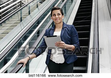 Stock Photograph - Hispanic businesswoman using tablet computer. Fotosearch