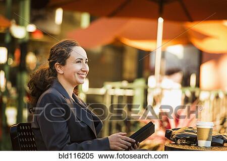 Stock Photography - Hispanic businesswoman working at cafe. Fotosearch