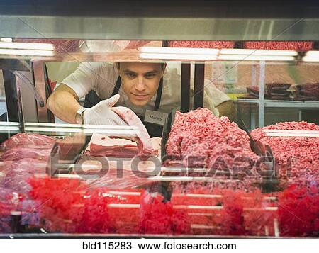 Hispanic butcher at meat counter of grocery store View Large Photo Image Stock Image - Hispanic butcher at meat counter of grocery store. Fotosearch