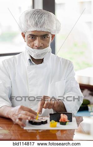 Stock Photo - Hispanic chef preparing sushi in restaurant. Fotosearch