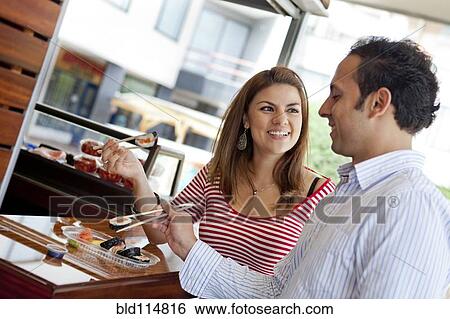 Hispanic couple eating sushi together View Large Photo Image Stock Photograph - Hispanic couple eating sushi together. Fotosearch