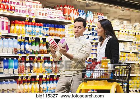 Stock Photo - Hispanic couple shopping in grocery store. Fotosearch