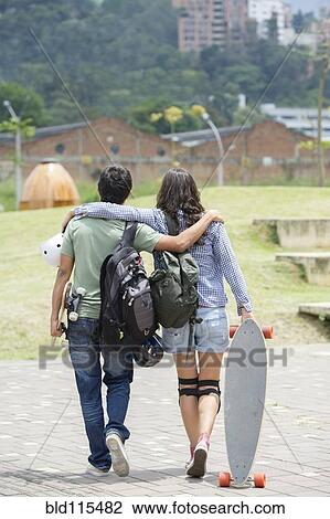Stock Image - Hispanic couple walking outdoors. Fotosearch