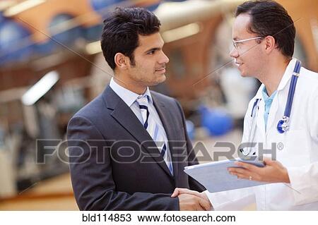 Hispanic doctor and businessman shaking hands View Large Photo Image Stock Image - Hispanic doctor and businessman shaking hands. Fotosearch