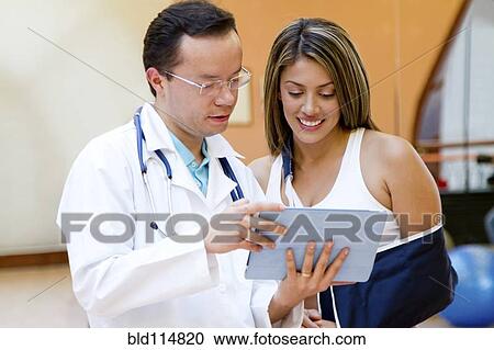 Hispanic doctor and patient using tablet computer View Large Photo Image Stock Image - Hispanic doctor and patient using tablet computer. Fotosearch