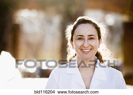 Picture - Hispanic doctor smiling outdoors. Fotosearch