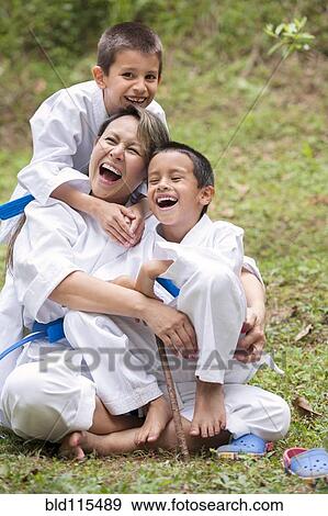 Stock Photo - Hispanic family wearing martial arts robes in grass. Fotosearch