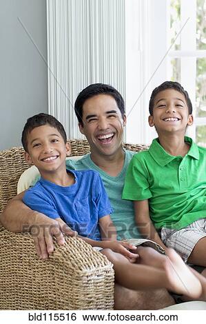 Hispanic father and sons sitting in armchair View Large Photo Image Stock Photograph - Hispanic father and sons sitting in armchair. Fotosearch