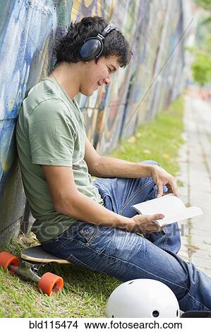 Picture - Hispanic man listening to headphones. Fotosearch