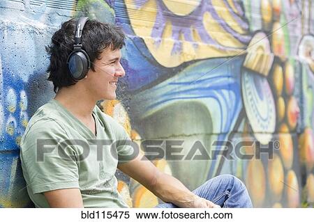 Stock Photography - Hispanic man listening to headphones. Fotosearch