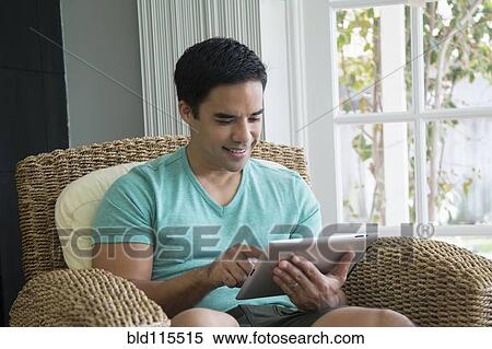 Hispanic man using digital tablet View Large Photo Image Stock Photography - Hispanic man using digital tablet. Fotosearch