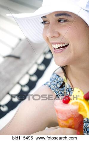 Stock Photography - Hispanic woman having fruity drink. Fotosearch