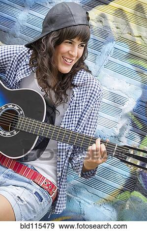 Hispanic woman playing guitar outdoors View Large Photo Image Stock Photo - Hispanic woman playing guitar outdoors. Fotosearch