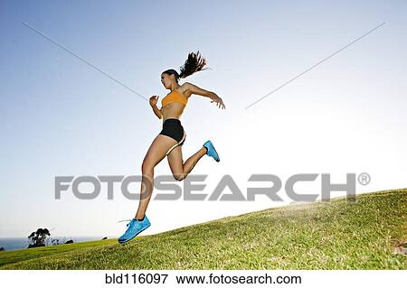 Stock Photo - Hispanic woman running in rural landscape. Fotosearch