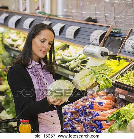 Hispanic woman shopping for produce in grocery store View Large Photo Image Stock Photo - Hispanic woman shopping for produce in grocery store. Fotosearch